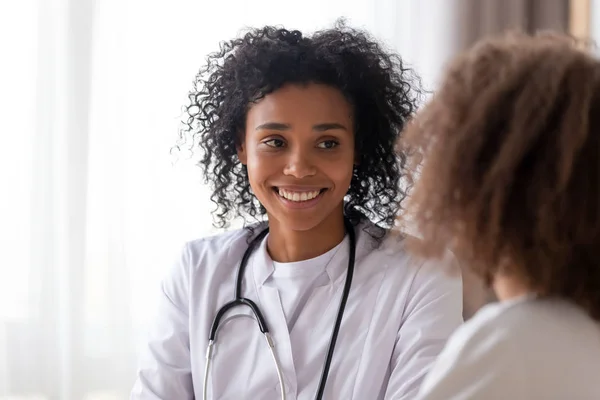 Z bliska uśmiechnięty African American lekarz pediatra słuchanie pacjenta — Zdjęcie stockowe
