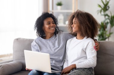 Afro-Amerikan anne ve kızı dizüstü bilgisayar kullanarak, birlikte eğlenmek