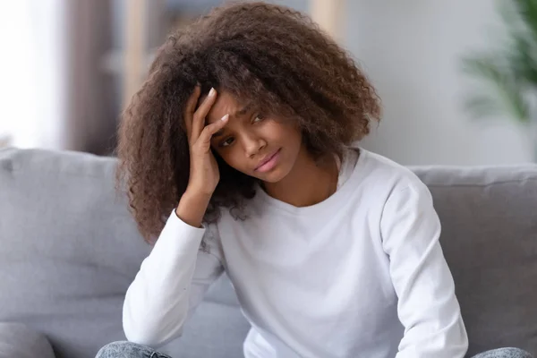 Niña adolescente afroamericana infeliz sentada sola, teniendo problemas —  Fotos de Stock
