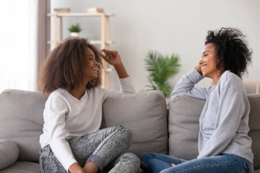 Mutlu Afrikalı Amerikalı anne ve genç kızı evde sohbet