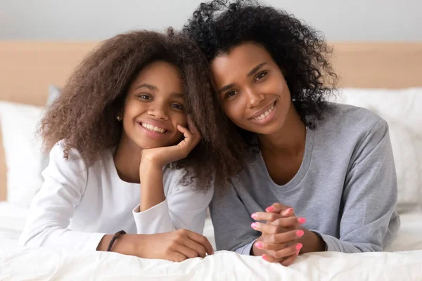 Head Shot porträtt av afroamerikansk mor och dotter på sängen — Stockfoto