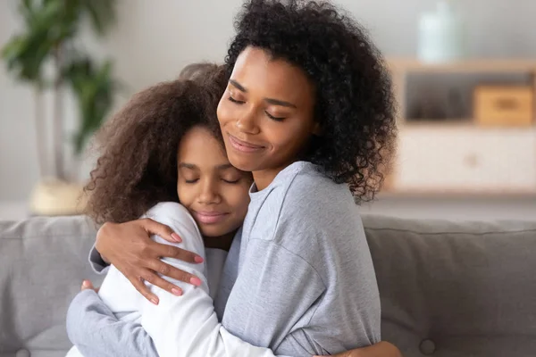 Afro-americanos mãe e filha abraçando, desfrutando de momento juntos — Fotografia de Stock