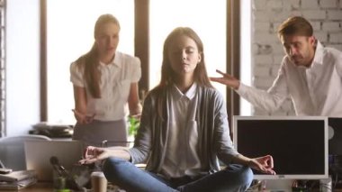 Sakin kadın çalışan kızgın rahatsız arkadaşları görmezden ofiste meditasyon