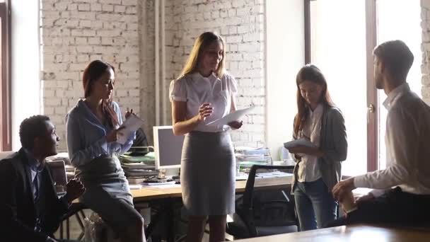 Mujer líder ejecutiva sosteniendo informe de papel charla instruyendo a los trabajadores del equipo — Vídeos de Stock