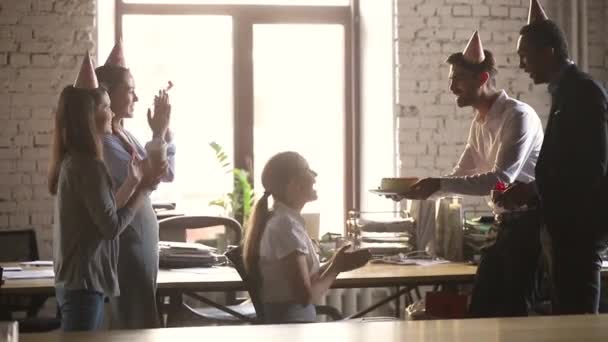 Equipo feliz en sombreros de fiesta felicitar a colega con pastel de cumpleaños — Vídeos de Stock