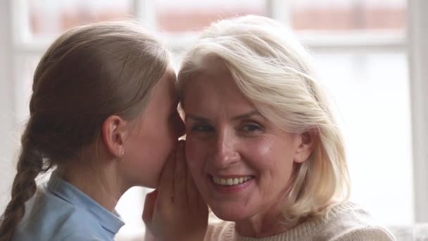 Nonna ascoltando la nipotina sussurrare in orecchio dicendo segreto — Video Stock