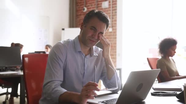 El hombre de negocios estresado con exceso de trabajo se quita las gafas se siente estresado en el trabajo — Vídeos de Stock