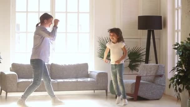 Actieve jonge moeder en Kid dochter dansen in de woonkamer — Stockvideo