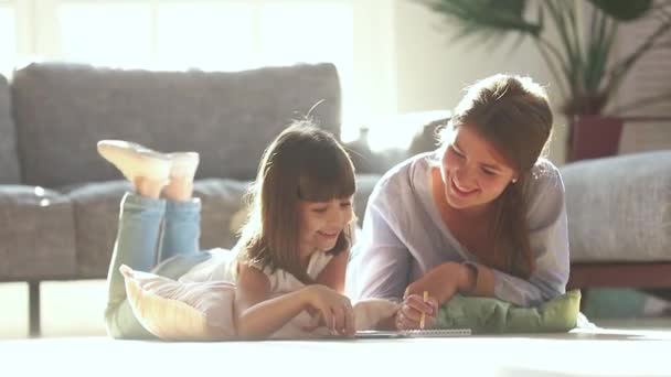 Madre feliz enseñanza linda niña dibujo en el piso caliente — Vídeos de Stock