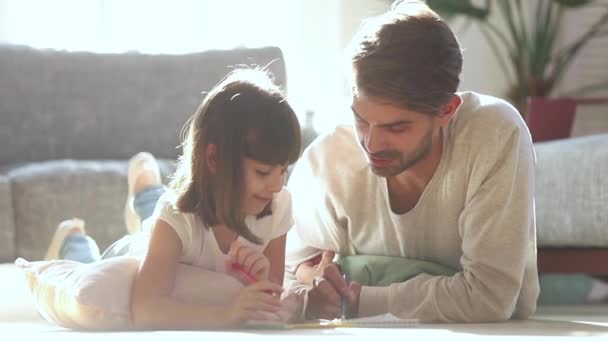 Papà e figlia bambino disegnano con matite sul pavimento caldo — Video Stock