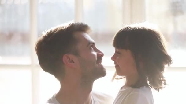 Милая девочка дочь и счастливый любящий отец обнимает трогательные носы — стоковое видео
