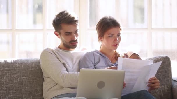 Coppia seria parlando avendo problemi con il pagamento delle bollette sul computer portatile — Video Stock