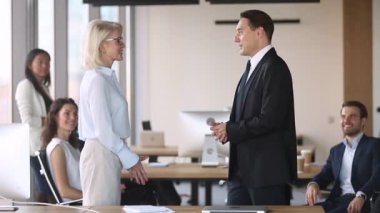 Orta yaşlı erkek yönetici tebrik el sıkışma gurur kadın çalışan teşvik