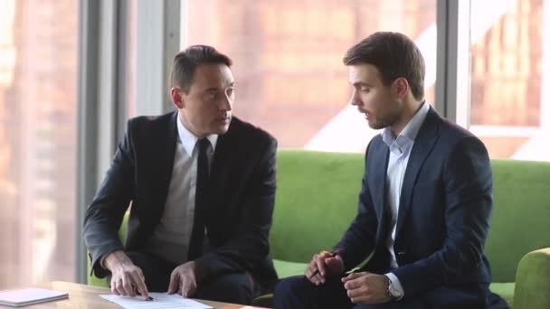 Dos hombres de negocios en trajes haciendo acuerdo acuerdo de apretón de manos firmando contratos — Vídeos de Stock