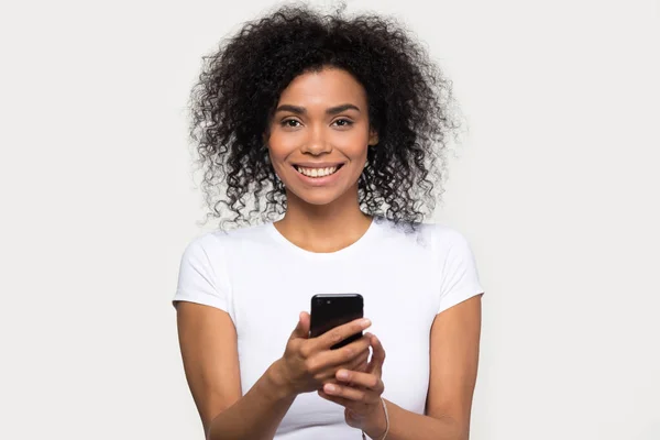 Headshot portret uśmiechnięty African kobieta trzyma smartphone patrząc na aparat fotograficzny — Zdjęcie stockowe