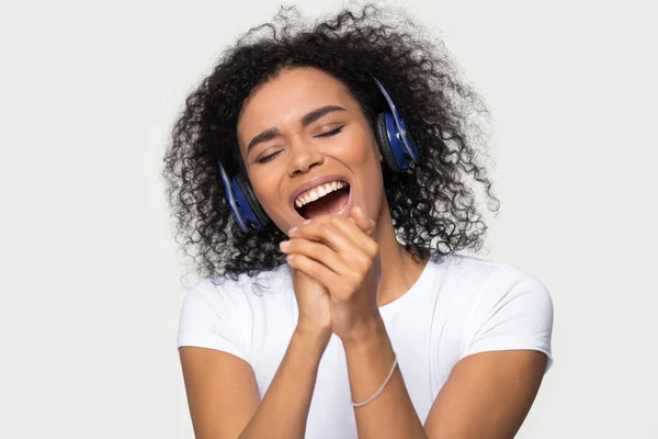 Femme africaine les yeux fermés avec casque chantant studio tourné — Photo