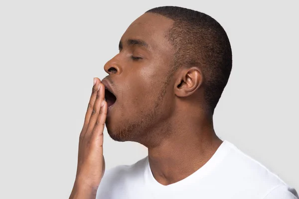 Closeup Africano perfil rosto masculino bocejo cobrindo a boca com a mão — Fotografia de Stock