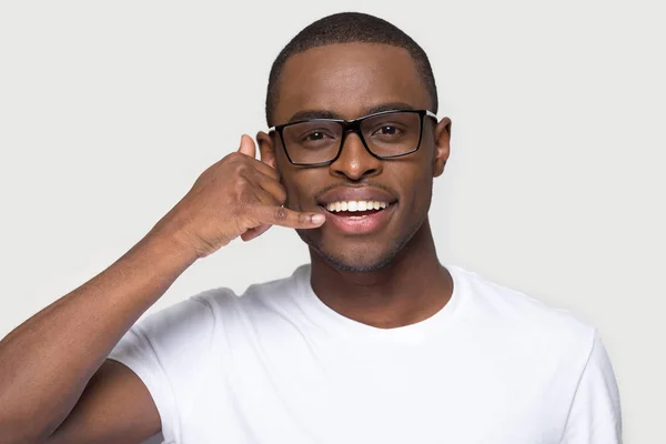 Afrikaanse man in brillen maken gebaar met de hand Bel me — Stockfoto