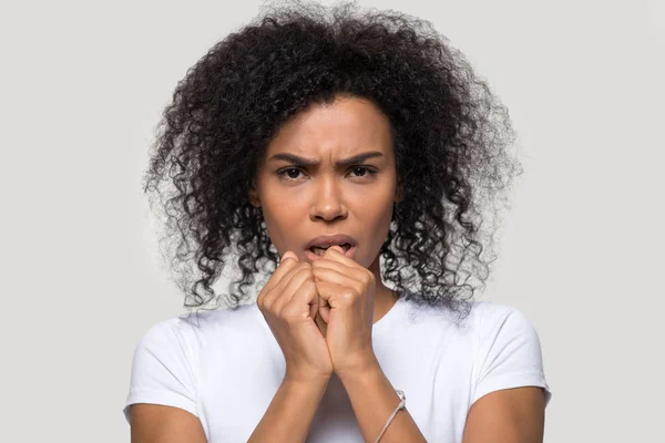 Fruncir el ceño mujer africana posar sobre gris en blanco mirando a la cámara — Foto de Stock