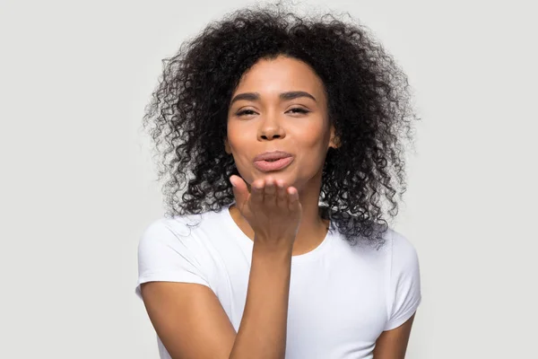 Lovely african young woman sending air kiss studio shot — Stock Photo, Image