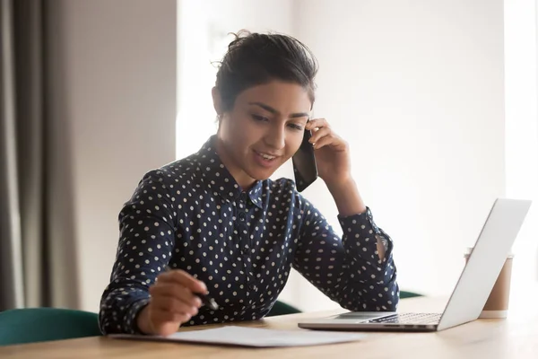 Drukke vrouwelijke Indiase werknemer praat op mobiele telefoon op de werkplek — Stockfoto