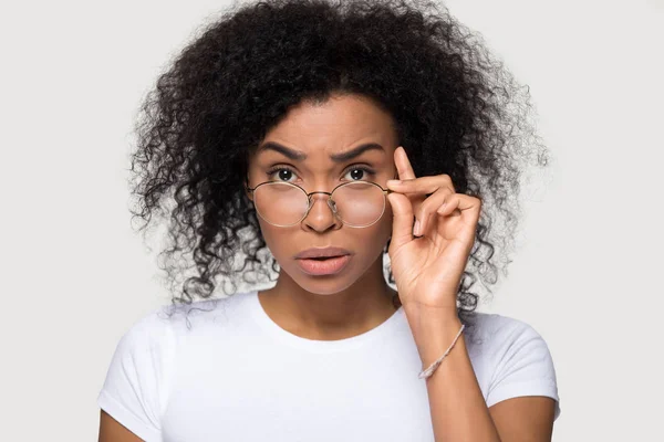 Chockad afrikansk ung kvinna sänka glasögon tittar på kamera — Stockfoto