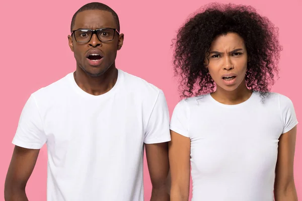 Casal africano chocado olhando para a câmera posando em estúdio — Fotografia de Stock