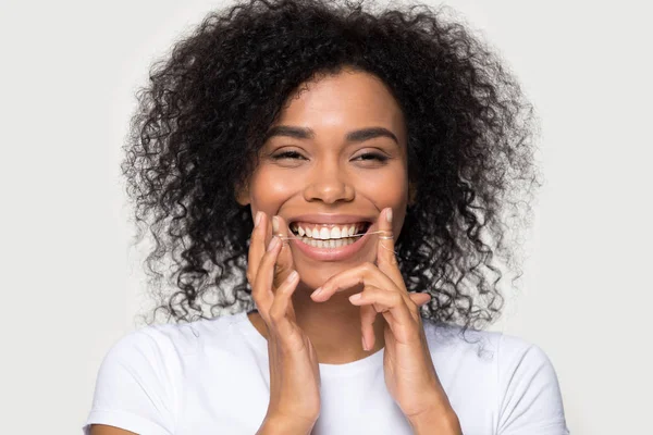 Closeup portre mutlu afrikalı kadın diş ipi ile diş temizliği — Stok fotoğraf