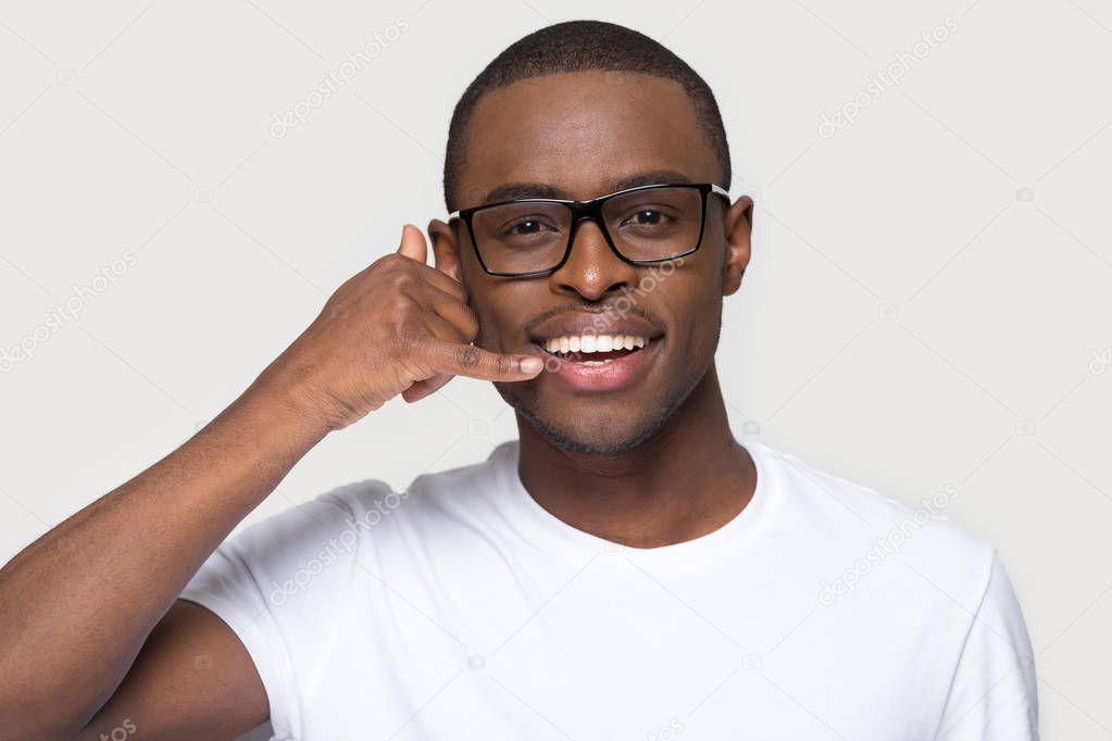 African man in eyeglasses make gesture with hand call me