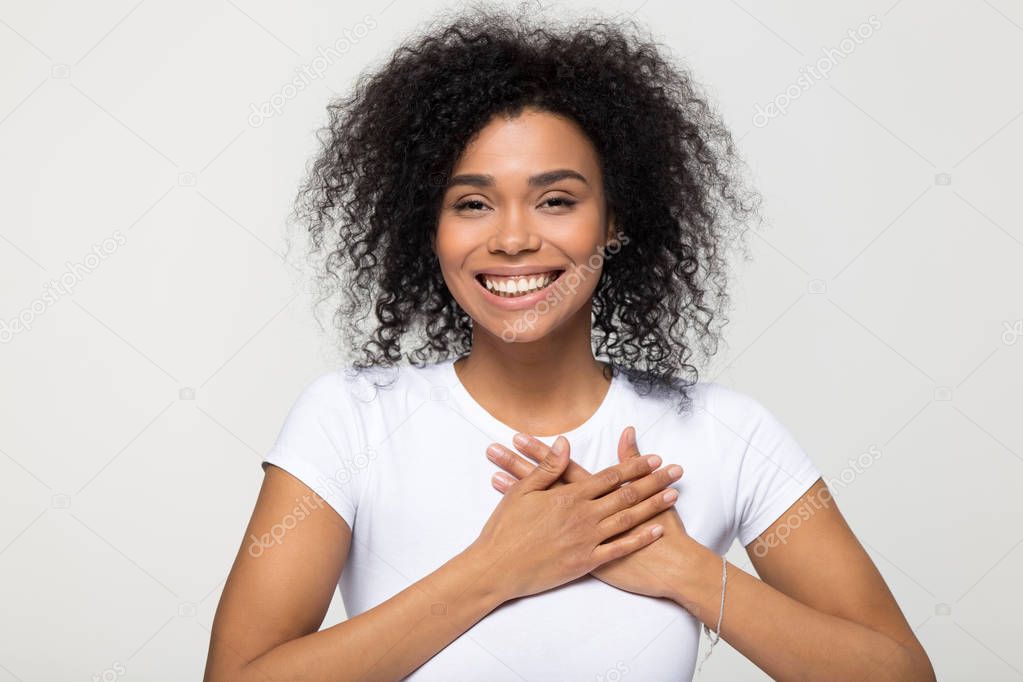 Headshot portrait american woman holding hand on heart feels gratitude