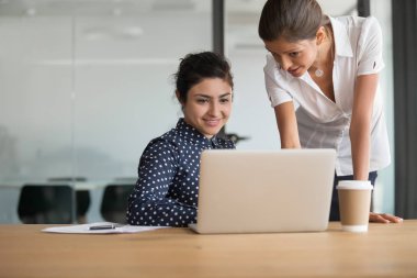 Kadın meslektaşları dizüstü bilgisayar kullanarak proje beyin fırtınası tartışmak