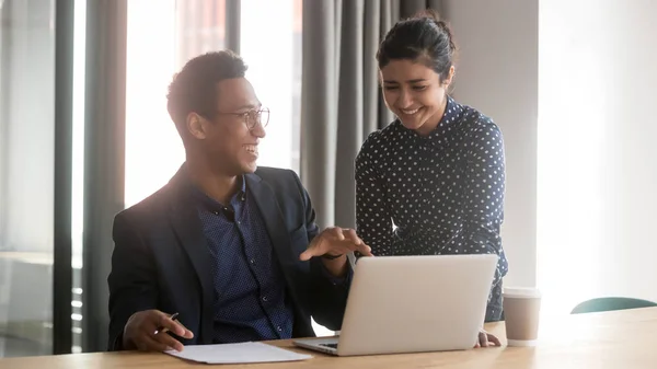 Glimlachend multi-etnisch divers collega's praten samenwerken bij laptop — Stockfoto