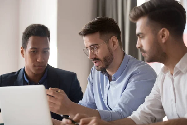 Seriösa manliga kollegor använder laptop diskuterar affärsidéer — Stockfoto