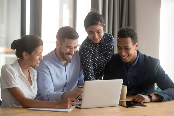 Glimlachend divers werknemers lachen samenwerken bij laptop in kantoor — Stockfoto
