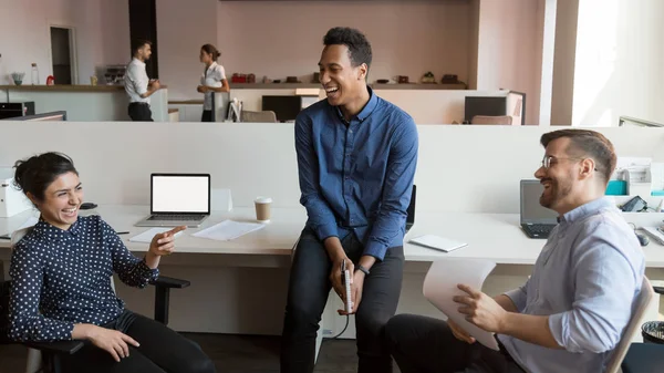 Glimlachende multi-etnische collega's lachen om te praten tijdens informele team Meeting — Stockfoto