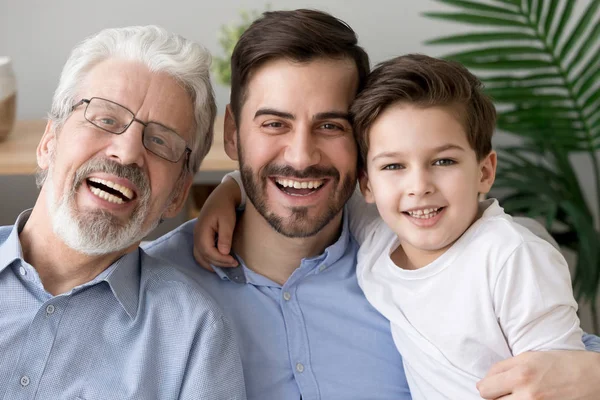 Portrait of three generations of men hug look at camera — Stock Photo, Image