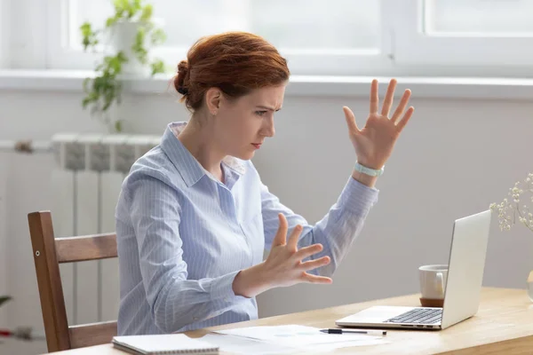 Arrabbiato donna d'affari sconvolto guardando schermo del computer portatile gesticolando con irritazione — Foto Stock