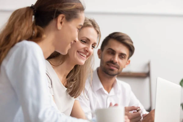 Joyful empleados de oficina que se divierten mirando a la pantalla del ordenador portátil — Foto de Stock