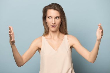 Şaşırmış genç kadın elleriyle büyük ölçekli ölçüm gösterisi