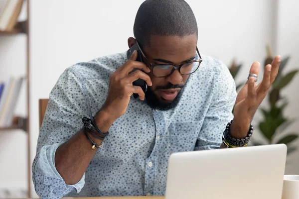 Arrabbiato pazzo uomo d'affari afro-americano che parla al cellulare in ufficio — Foto Stock