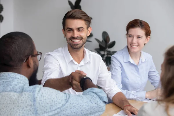 Feliz sonriente caucásico macho manager sacudiendo mano africano-americano colega — Foto de Stock