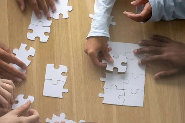 Top above close up view multiracial human hands assembling puzzle — Stock Photo, Image