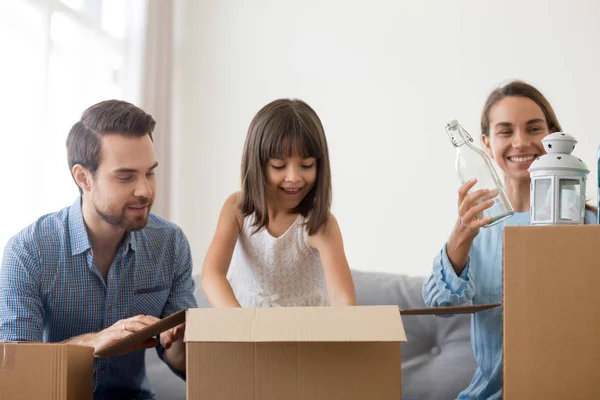 Famiglia eccitata con i bambini disfare le scatole trasferirsi in una nuova casa — Foto Stock