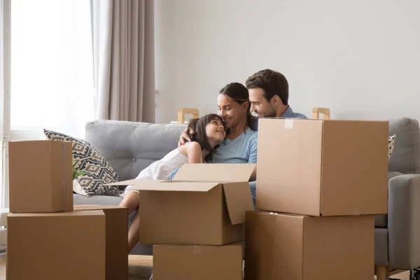 Happy family with daughter relax on couch on moving day