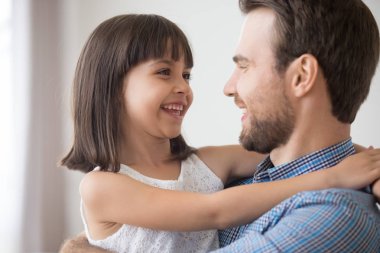 Gülümseyen baba birlikte gülerek kollarını kızı tutun