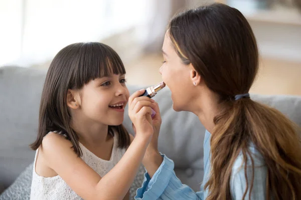 Divertido joven mamá y preescolar hija hacer maquillaje juntos — Foto de Stock