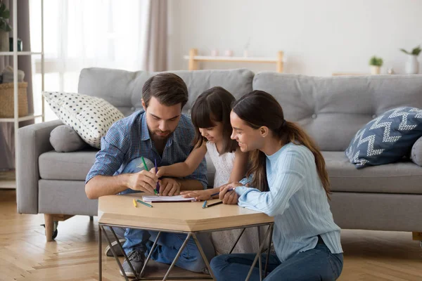 Los padres jóvenes se relajan pintando junto con su hija pequeña — Foto de Stock