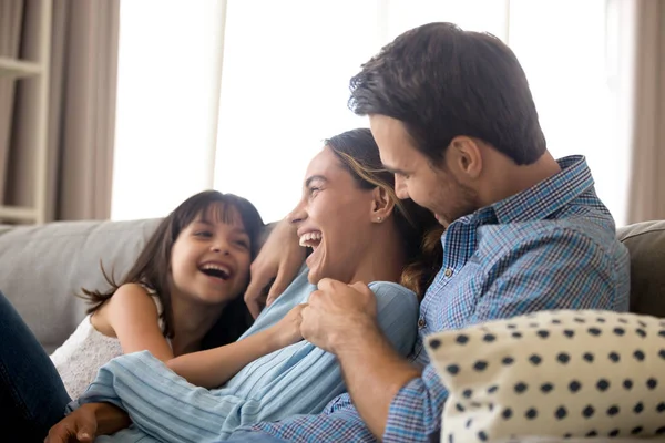 Mutlu aile kanepede rahatlatıcı gülerek eğlenin — Stok fotoğraf