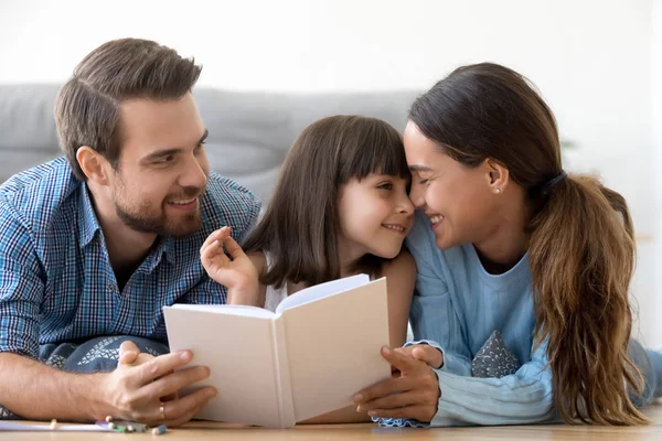 Любящие родители наслаждаются расслабляющим чтением с маленькой дочерью — стоковое фото