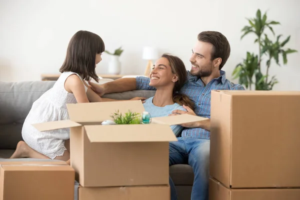 Les parents heureux s'amusent avec l'enfant se détendre le jour du déménagement — Photo